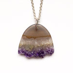 Load image into Gallery viewer, Carved Amethyst statement pendant. Hand carved raw amethyst in an elongated half oval with a raw crystal edge.
