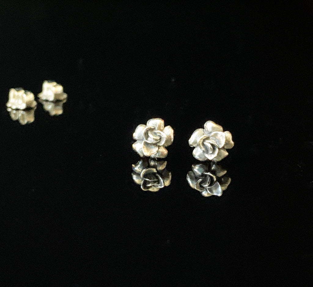 Sterling silver stud earrings in the shape of a small rose or flower.