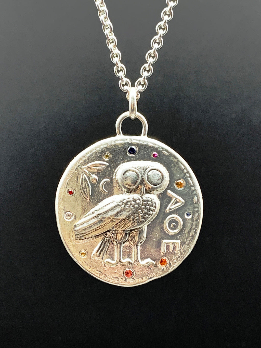 Athena owl coin pendant in sterling silver, set with ten colored sapphires.
